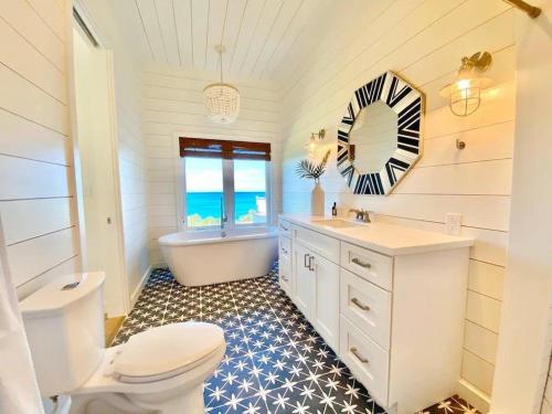 een badkamer met een toilet, een bad en een wastafel bij Azure home in Palmetto Point