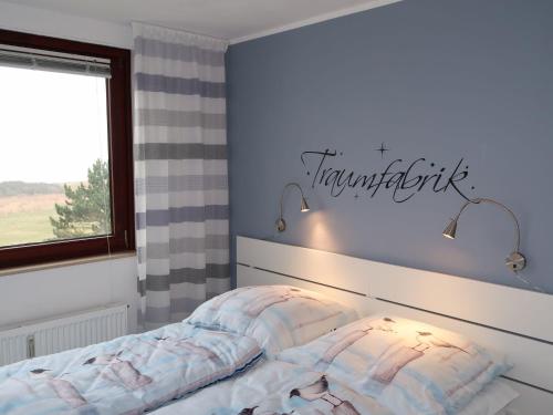 1 dormitorio con 1 cama con un cartel en la pared en Apartment Ostsee Residenz by Interhome, en Damp