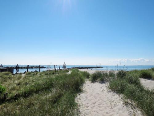 a sandy beach with a pier in the background at Apartment Sander by Interhome in Damp