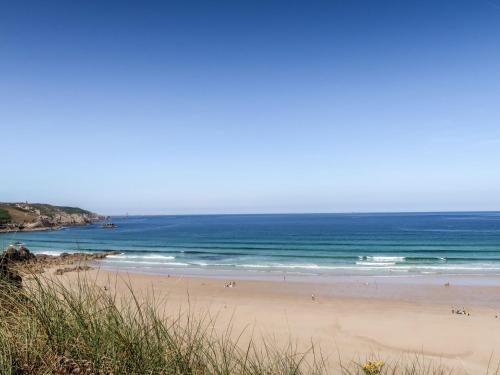 a beach with people on the sand and the ocean at Holiday Home La petite Iroise by Interhome in Plogoff