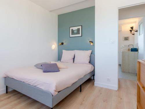 une chambre avec un lit avec un mur bleu dans l'établissement Apartment Les Mouettes by Interhome, à Jullouville