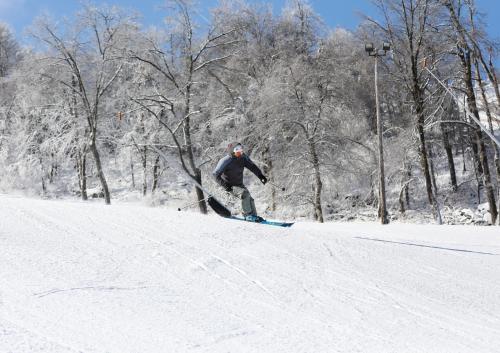 a man riding a snowboard down a snow covered slope at Seven Springs 3 Bedroom Standard Condo with Private Deck condo in Champion