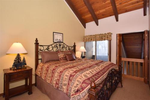 a bedroom with a large bed and a wooden ceiling at Seven Springs 3 Bedroom Standard Townhouse, Sleeps 11! condo in Champion