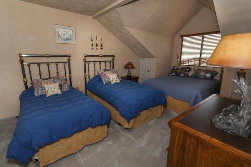 1 Schlafzimmer mit 2 Betten und blauen Bettdecken in der Unterkunft Seven Springs Sunridge 3 Bedrooms Premium Condo, Pet Friendly! condo in Champion