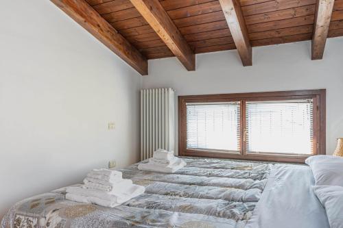 a bedroom with a large bed with towels on it at Parma Parco Ducale Duplex Apartment with parking in Parma