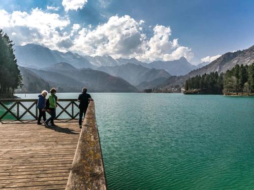 a group of people standing on a wooden pier overlooking a lake at Studio Albergo Diffuso - Cjasa de Pagnocca by Interhome in Barcis