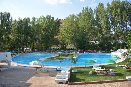 una gran piscina con gente sentada a su alrededor en HOSTAL LA CAÑADA RUIDERA en Ossa de Montiel