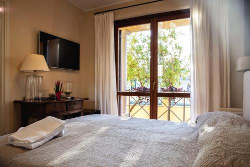 1 dormitorio con 1 cama y puerta corredera de cristal en Guest House DaLù, en Dorgali
