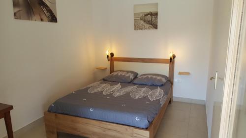 un lit dans une chambre avec deux oreillers dessus dans l'établissement Mas de la berlusiere chambres d hotes en ardeche du sud, à Saint-André-de-Cruzières