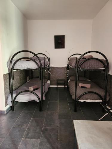 three bunk beds in a room with a tile floor at Hostel Turin Metro Young in Turin