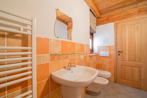 ein Badezimmer mit einem Waschbecken, einem WC und einem Spiegel in der Unterkunft Civico 2 in Marmora