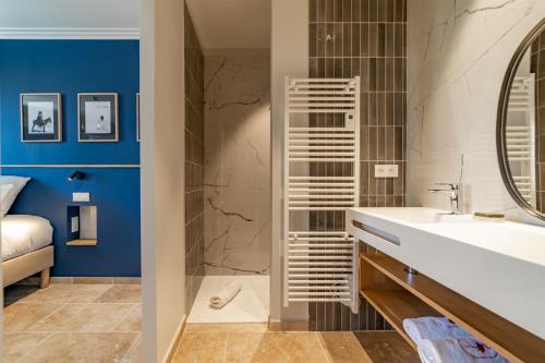 La salle de bains est pourvue d'un lavabo blanc et d'un miroir. dans l'établissement Marcelle en Camargue, à Aigues-Mortes