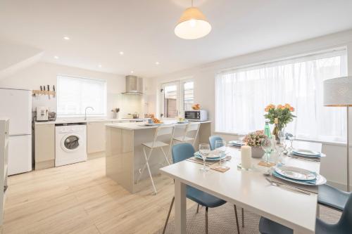 a kitchen and dining room with a table and chairs at Elegant home mod kitchen, fast Wi-Fi, free parking in Carrickfergus