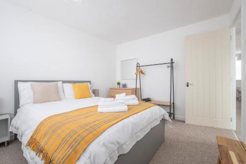 una camera da letto con un grande letto con una coperta arancione di Elegant home mod kitchen, fast Wi-Fi, free parking a Carrickfergus
