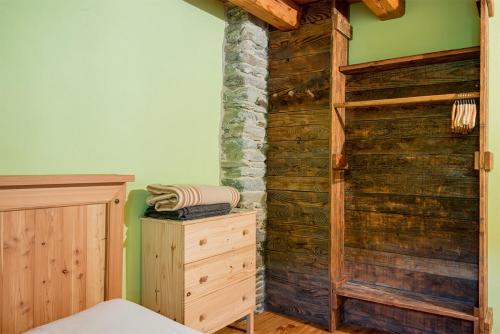 una camera da letto con parete in legno e comò in legno di Civico 12 a Marmora