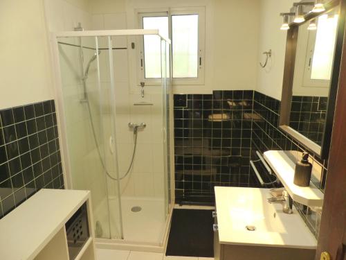 La salle de bains est pourvue d'une douche en verre et d'un lavabo. dans l'établissement Villa DOUS REPAOUS pour 5 personnes entre lac et océan, à Soorts-Hossegor