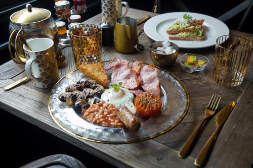 a wooden table with a plate of breakfast food on it at The Twenty One in Brighton & Hove