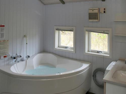 ein weißes Bad mit einer Badewanne und einem WC in der Unterkunft Holiday Home Aasa - 200m from the sea in Western Jutland by Interhome in Fanø