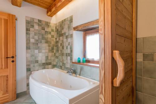 a bathroom with a white tub and a window at Civico 9 in Marmora