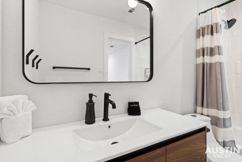 a bathroom with a white sink and a mirror at Insta-Ready Apartment in Barton Hills w King Bed in Austin