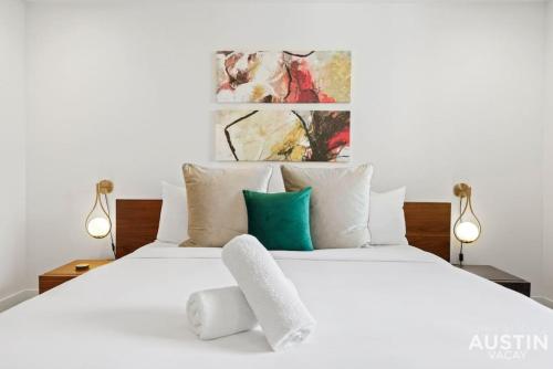 a white bed with white pillows and green accents at Insta-Ready Apartment in Barton Hills w King Bed in Austin