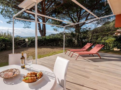uma mesa com um prato de comida e uma garrafa de vinho em Holiday Home Villa Marzia Mare & Golf by Interhome em Punta Ala