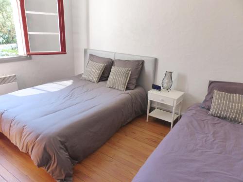 sypialnia z dużym łóżkiem i stolikiem nocnym w obiekcie Villa DOUS REPAOUS pour 5 personnes entre lac et océan w mieście Soorts-Hossegor