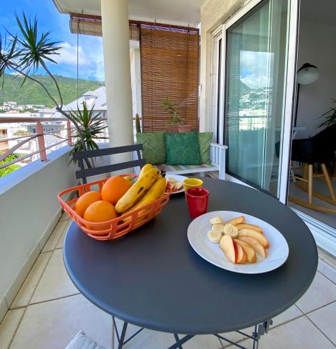 a table with a basket of fruit on a balcony at Appartement lumineux et calme Saint-Denis centre in Saint-Denis