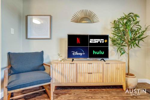 a living room with a chair and a tv on a cabinet at Get Comfy Memory Foam Beds and Tub in Central ATX in Austin