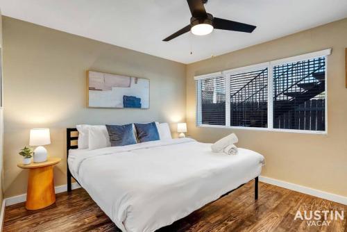 um quarto com uma grande cama branca e uma janela em Get Comfy Memory Foam Beds and Tub in Central ATX em Austin