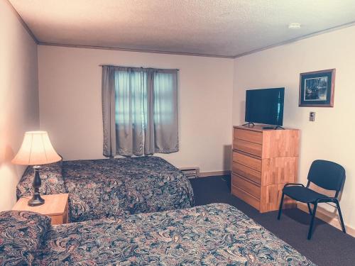 a hotel room with two beds and a television at Draft House & Lodge in Delta Junction