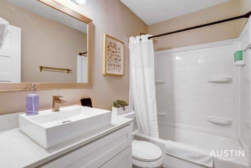 uma casa de banho com um lavatório, um WC e um chuveiro em Get Comfy Memory Foam Beds and Tub in Central ATX em Austin