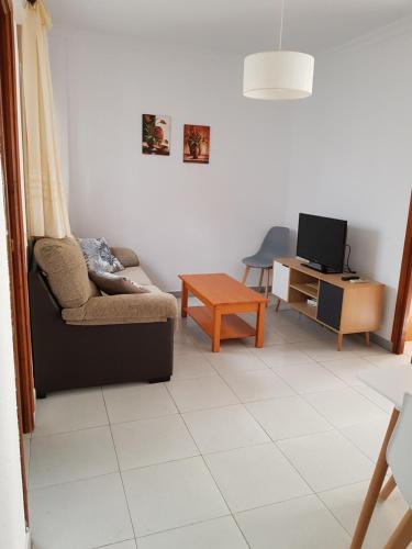 ein Wohnzimmer mit einem Sofa und einem TV in der Unterkunft Apartamento Antonio Machado in Barbate