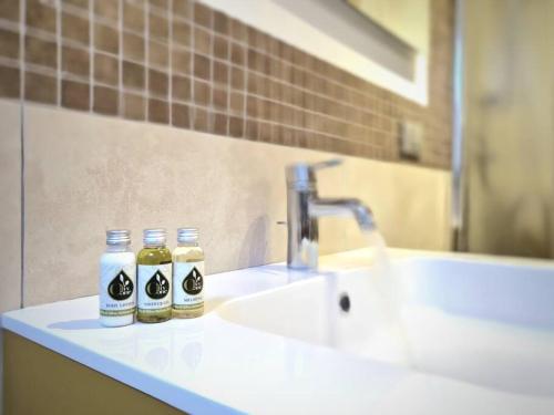 a bathroom sink with two bottles of soap on it at [LOFT Romantico] Vista Panoramica vicino al Mare in Lido di Fermo