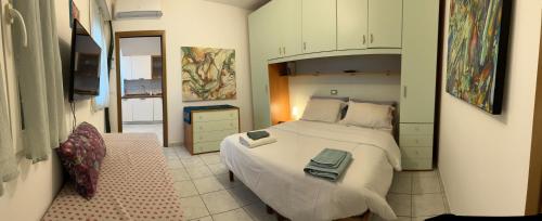 ein Schlafzimmer mit einem großen weißen Bett in einem Zimmer in der Unterkunft AppArt 21 in Lignano Sabbiadoro