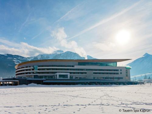 a large building with snow in front of mountains at Chalet Waltl by Interhome in Fusch an der Glocknerstraße