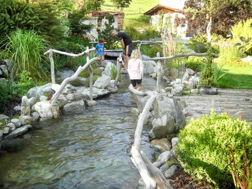 two children crossing a wooden bridge over a creek at Chalet Sturmbachhütte by Interhome in Uttendorf