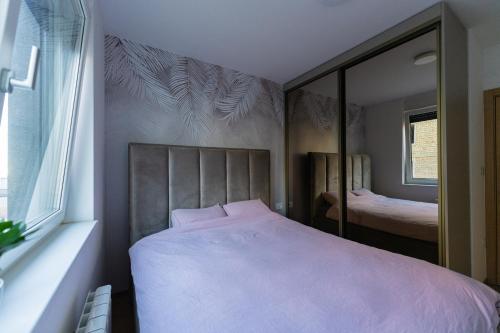 a bedroom with a large bed and a mirror at Superman in Novi Sad
