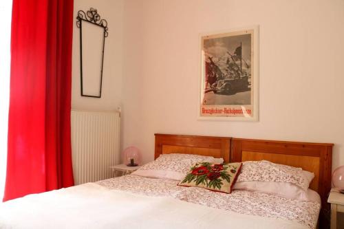 a bedroom with a bed with a red curtain at Stilhaus-Zimmer im Herzen des Drautales in Feistritz an der Drau