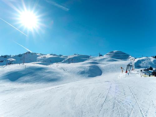 a snow covered slope with the sun in the sky at Apartment Rosalie by Interhome in Hart im Zillertal