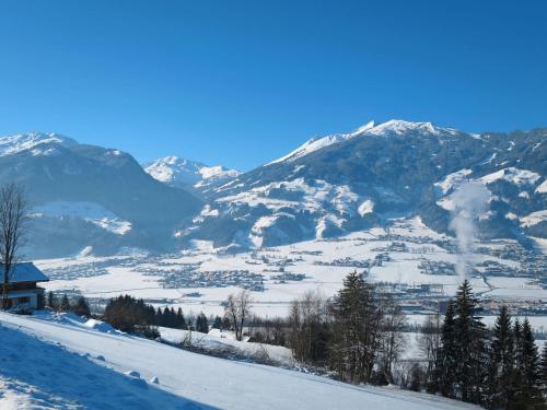a snow covered mountain range with a house in the foreground at Apartment Rosalie by Interhome in Hart im Zillertal
