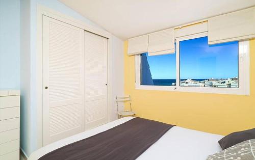 1 dormitorio con cama y ventana grande en Ático Medina Molins, en Denia
