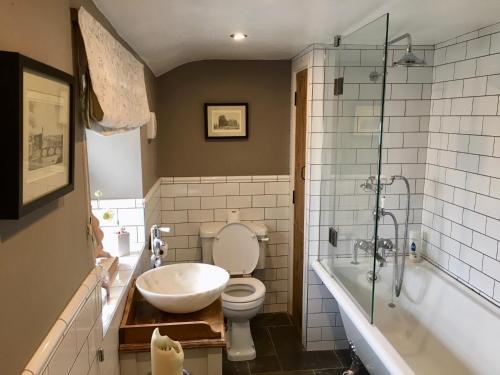 y baño con lavabo, aseo y bañera. en Garden Cottage, en Wetherby