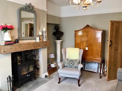 a living room with a chair and a mirror at Garden Cottage in Wetherby