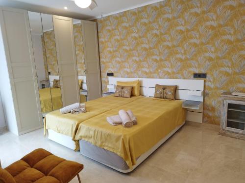 a bedroom with a large bed with a yellow bedspread at Modern luxury villa Paradise in Calpe