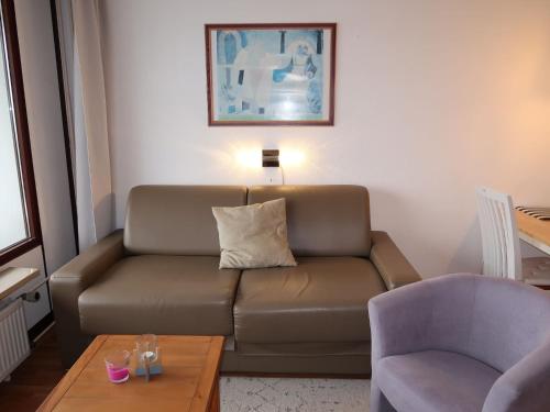 ein Wohnzimmer mit einem braunen Sofa und einem Tisch in der Unterkunft Apartment Ostsee-Residenz - DMP173 by Interhome in Damp