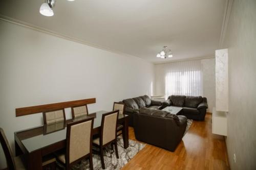 una sala de estar con un sofá, una mesa y sillas en Kruzer centar, en Nikšić