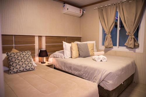 um quarto de hotel com duas camas e uma janela em Hospedagem Vila Suiça Centro em Gramado