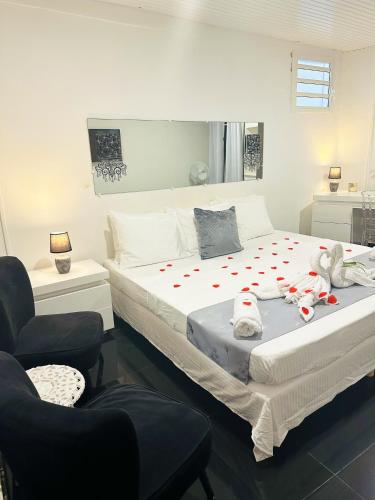 a bedroom with two beds and a chair at Appartement d'une chambre avec piscine partagee terrasse amenagee et wifi a Sainte Rose in Sainte-Rose