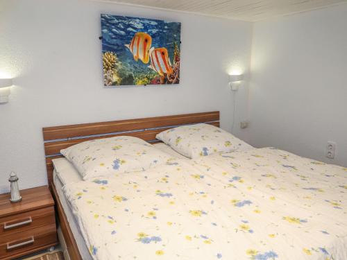 a bedroom with a bed and a painting on the wall at Apartment Osterende-2 by Interhome in Süderwisch